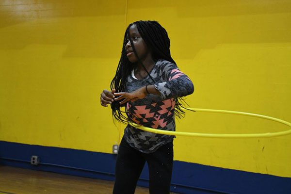 A woman is playing with a hula hoop